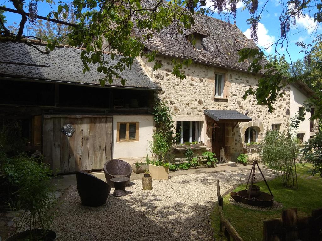 een groot stenen huis met een binnenplaats ervoor bij La Ferme Les Mamours in La Bastide-lʼÉvêque