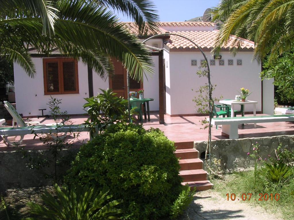 une maison avec une terrasse, une table et des chaises dans l'établissement Scopello Villa Sole, à Scopello