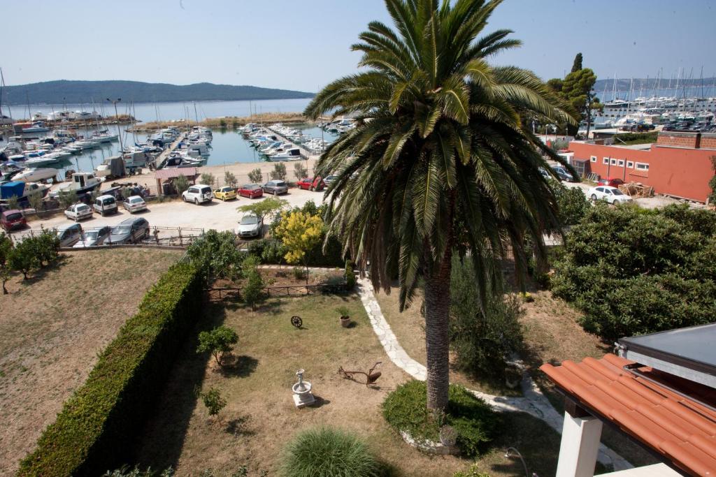 a palm tree on a balcony with a marina at Yacht Beach Apartments in Kaštela