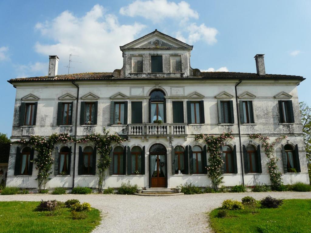 an old white house with ivy on it at Villa Caotorta in Ponzano Veneto