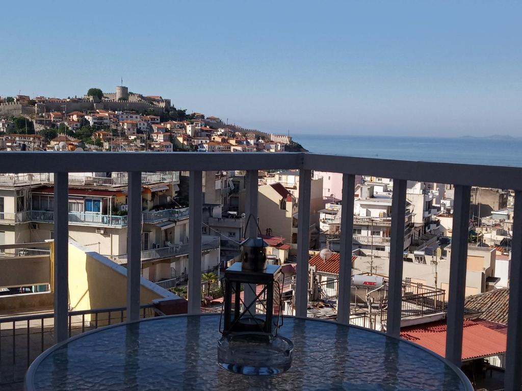 a table on a balcony with a view of a city at Castle View Apartment in Kavala