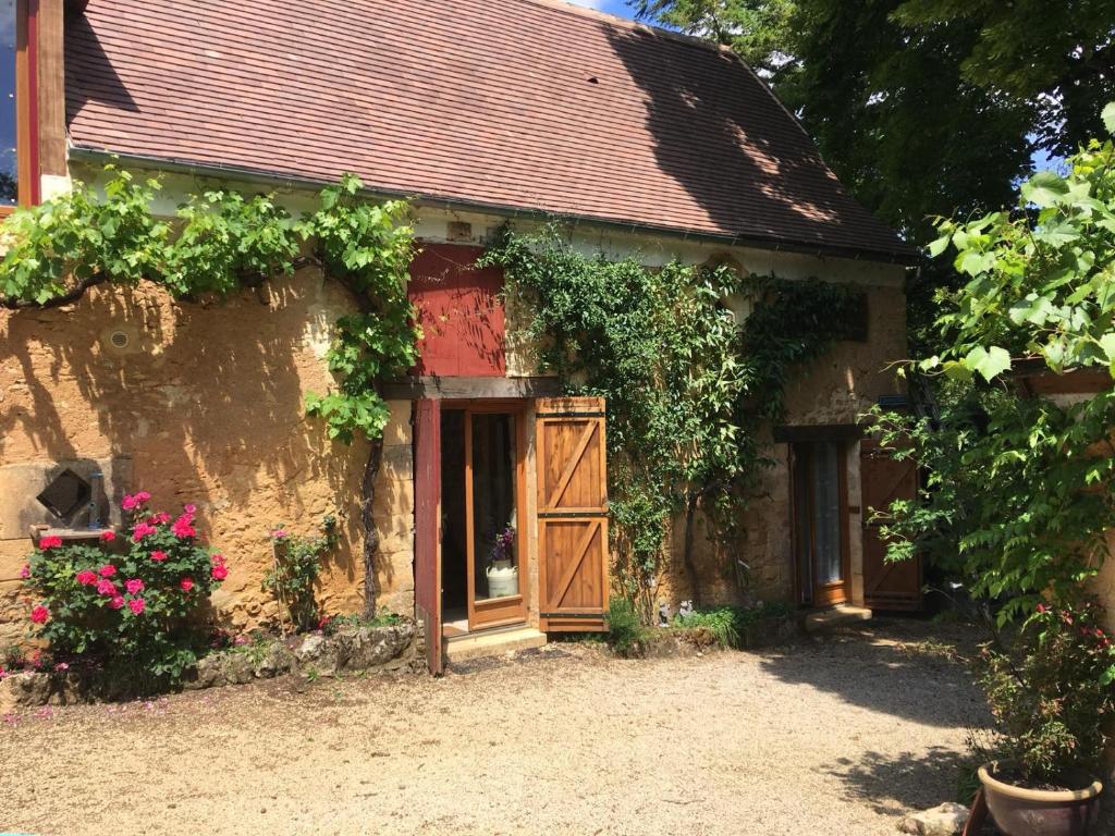 un antico edificio in pietra con porta in legno di Chambres d'hotes Les Coustilles a Saint-Alvère