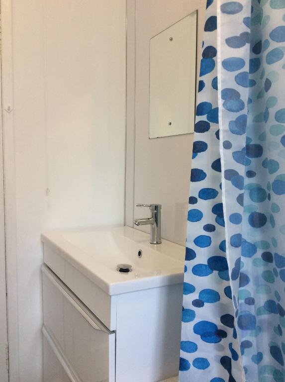 a bathroom with a sink and a shower curtain at Baker Street Apartment in Stirling