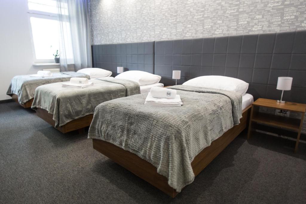 a room with three beds with towels on them at N°50 in Poznań