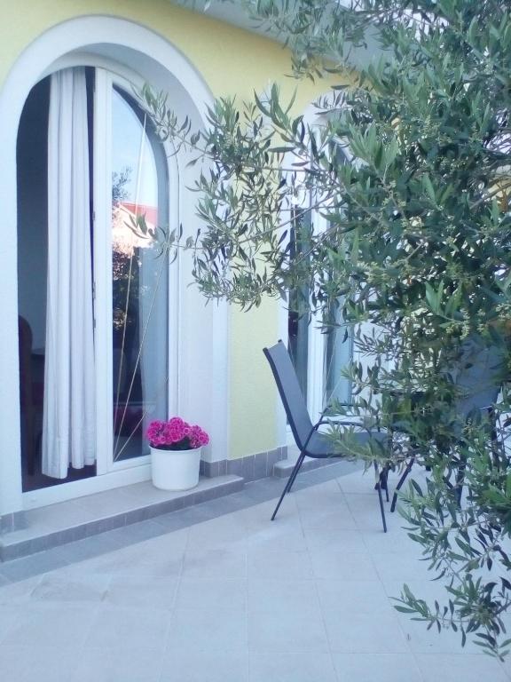a chair on a balcony with a window at Ana Rooms in Krk