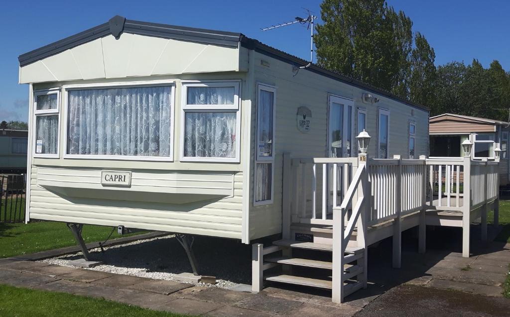 a tiny house with a porch and a staircase at Caravan 6 Berth North Shore Holiday Centre with 5G Wifi in Winthorpe