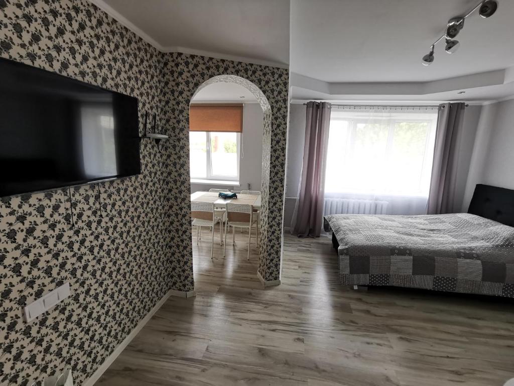 a bedroom with a bed and a flat screen tv at Central Sun in Daugavpils