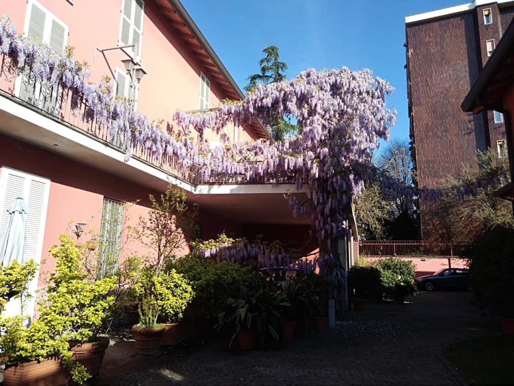 um edifício com um ramo de flores roxas numa varanda em Milano in Voga em Milão
