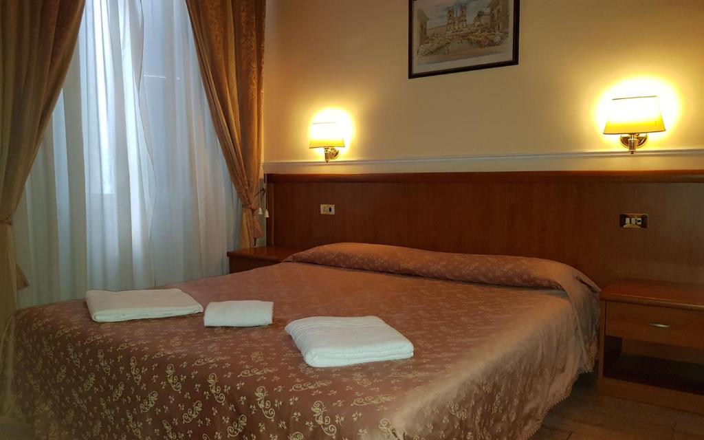 una camera da letto con un letto e due asciugamani di Hotel Aristotele a Roma