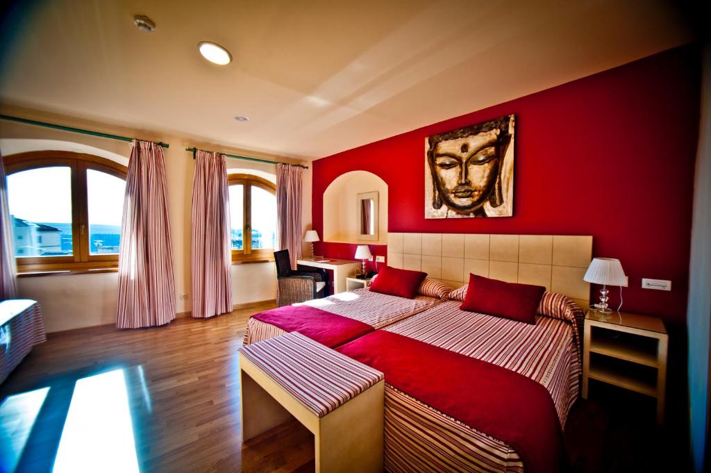 
a hotel room with a bed and a dresser at Hotel Condes de Castilla in Segovia
