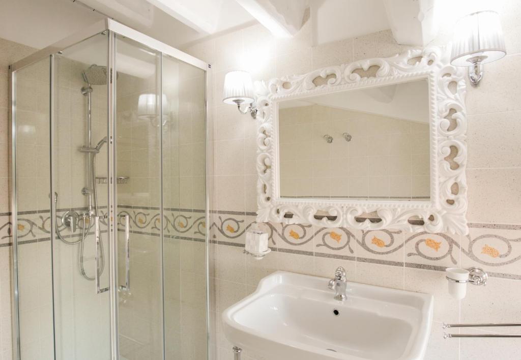 a bathroom with a sink and a shower and a mirror at B&B Monsignore in Vieste