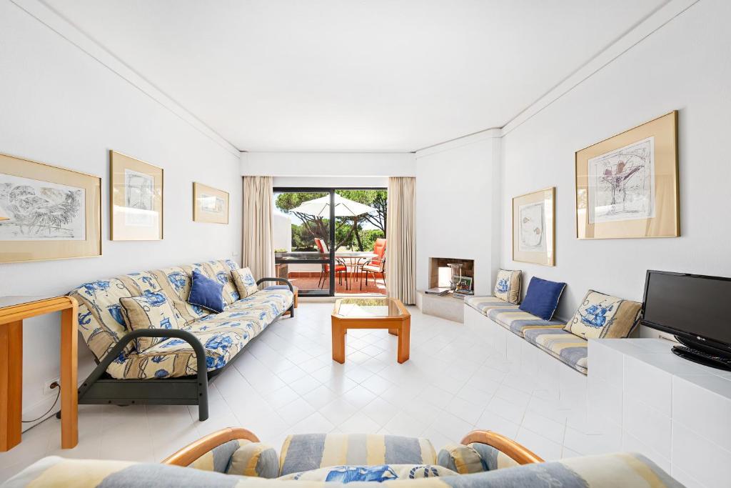 a living room with couches and a flat screen tv at Victory Village 10D in Quinta do Lago