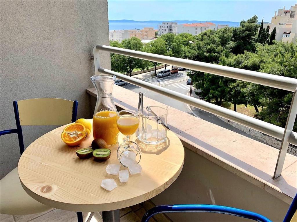 einen Tisch mit Orangen und Gläsern Orangensaft auf dem Balkon in der Unterkunft Sea Star in Split