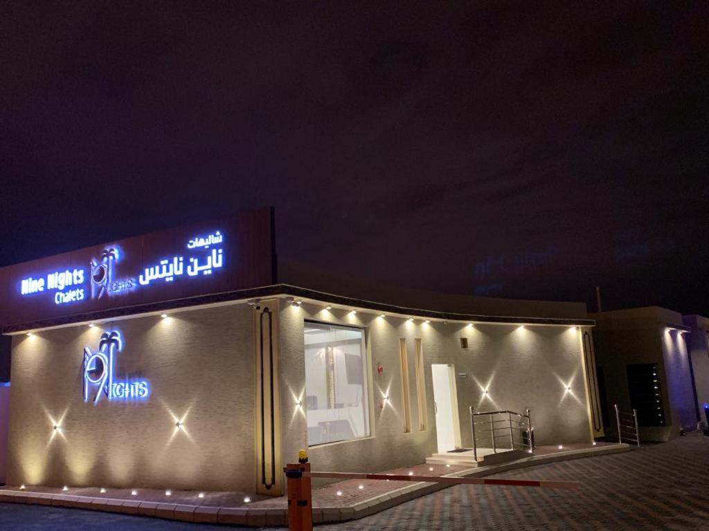 a building with lights on the side of it at Nine Nights Chalet For Families in Ahad Rafidah