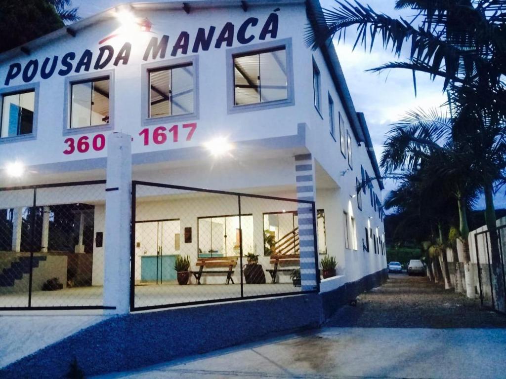 a white building with a sign that reads possada manaza at Pousada Manacá in São José do Rio Pardo