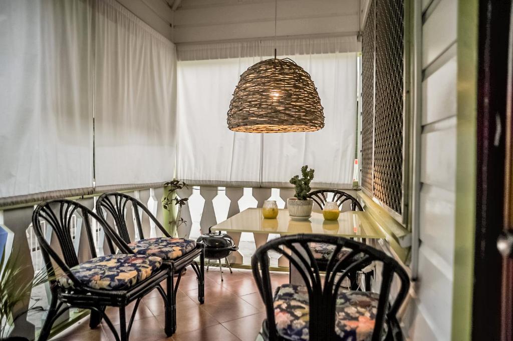 a dining room with chairs and a table and a chandelier at Eko Cozy Guest House in Saint Johnʼs