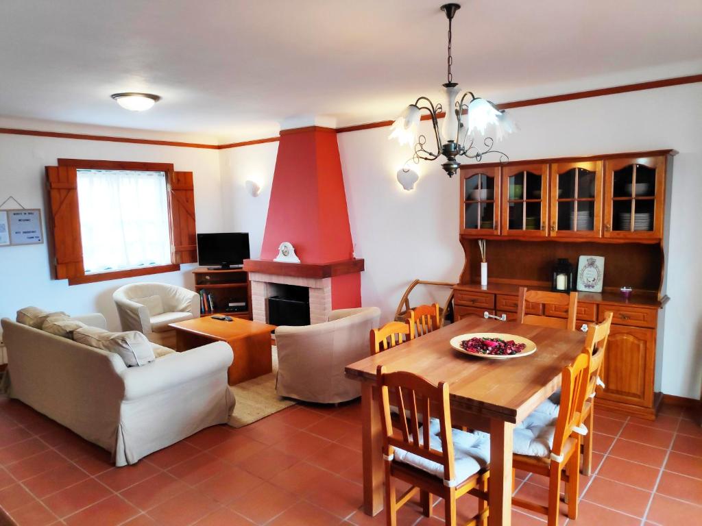 cocina y sala de estar con mesa y chimenea en Space Monte da Rosa en Vila Nova de Milfontes