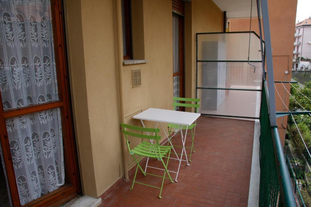 een balkon met een tafel en stoelen en een koelkast bij INTERNO 12 in Varazze