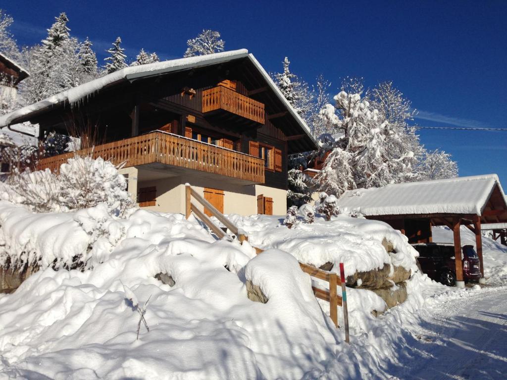 une maison recouverte de neige devant elle dans l'établissement Chalet du Meilly, à Saint-Gervais-les-Bains
