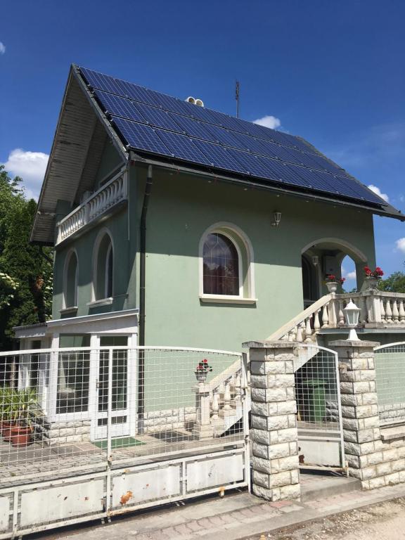 una casa con paneles solares en el techo en Tassi Halászcsárda-Harcsa ház, en Tass