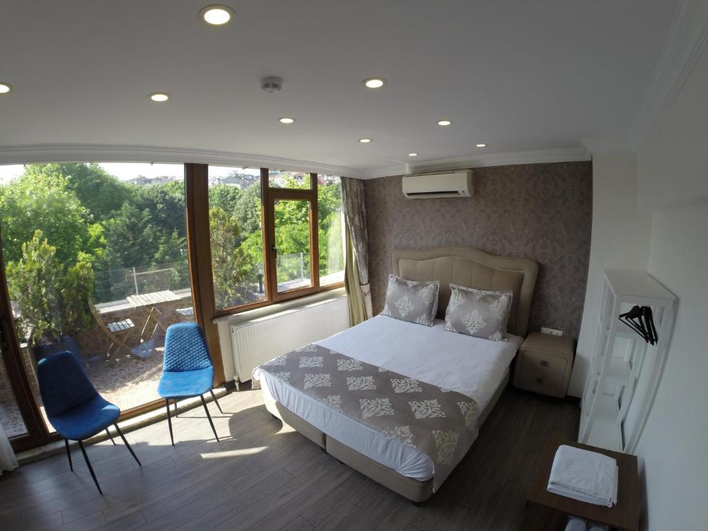 a bedroom with a bed and two blue chairs at Meydan Suites in Istanbul