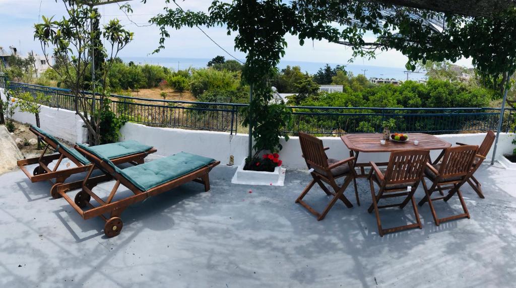 patio ze stołem i krzesłami z widokiem w obiekcie Stegna Breeze w mieście Archangelos