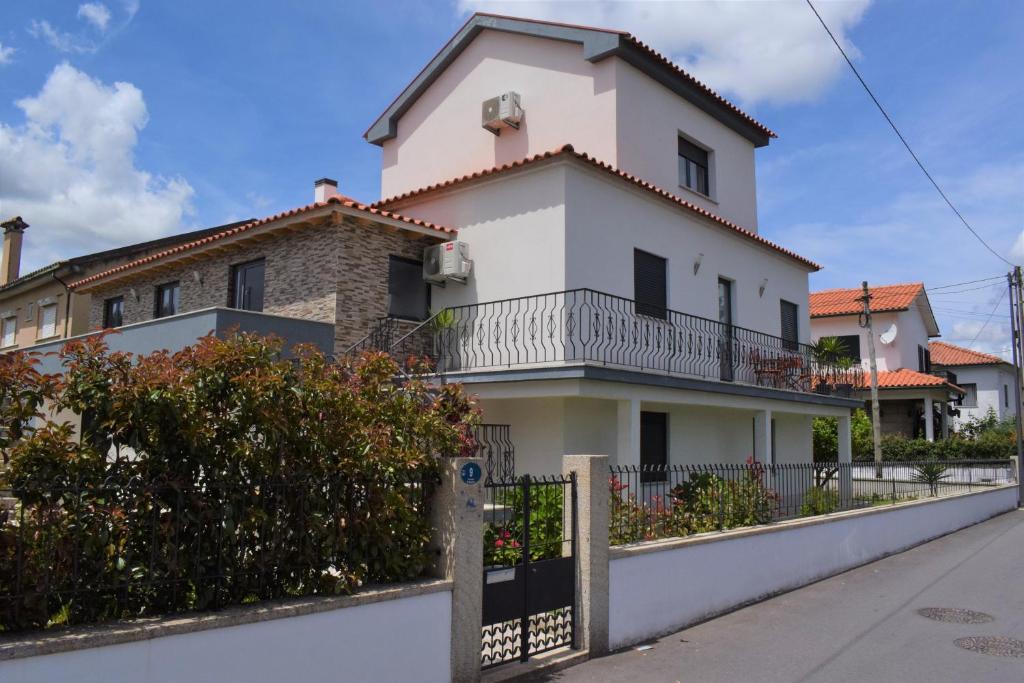 uma casa branca com uma cerca à frente. em Casa da Romeira em Ponte de Lima