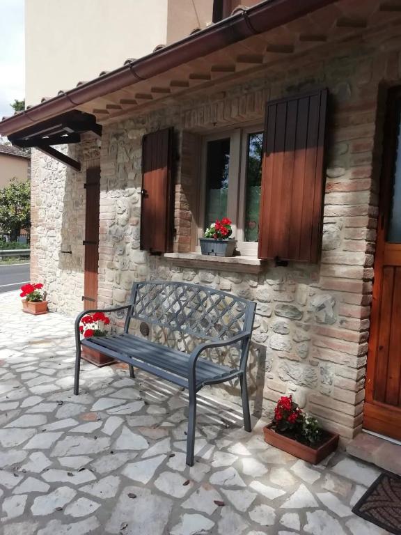 a bench sitting in front of a house at La Casetta della letizia in Colle