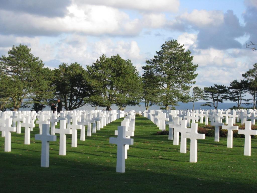 a group of white graves on the grass at Villa kahlo Omaha Beach in Colleville-sur-Mer