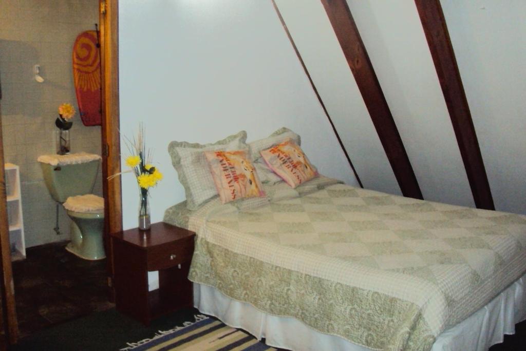 um quarto com uma cama com almofadas e um WC em Habitaciones Florencia em La Serena