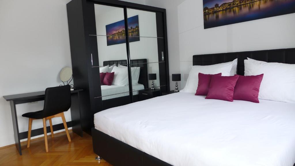 a bedroom with a white bed and a desk and a chair at Apartment Spartium Split in Split