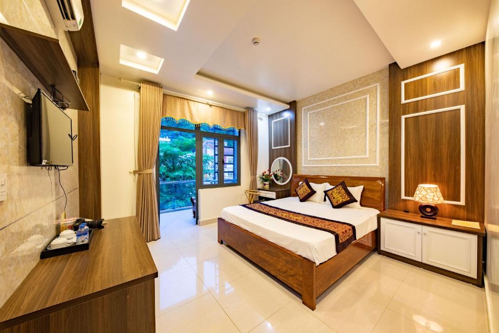 - une chambre avec un lit et une télévision dans l'établissement Thuong Hai Hotel, à Phong Nha