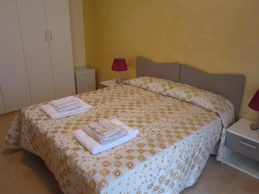 B&B Casa Murgiana في غرافينا إن بوليا: غرفة نوم عليها سرير وفوط