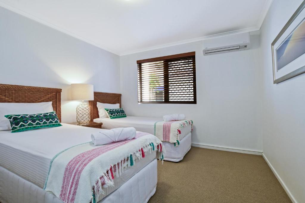 a bedroom with two beds and a window at Beachport Apartments in Mooloolaba