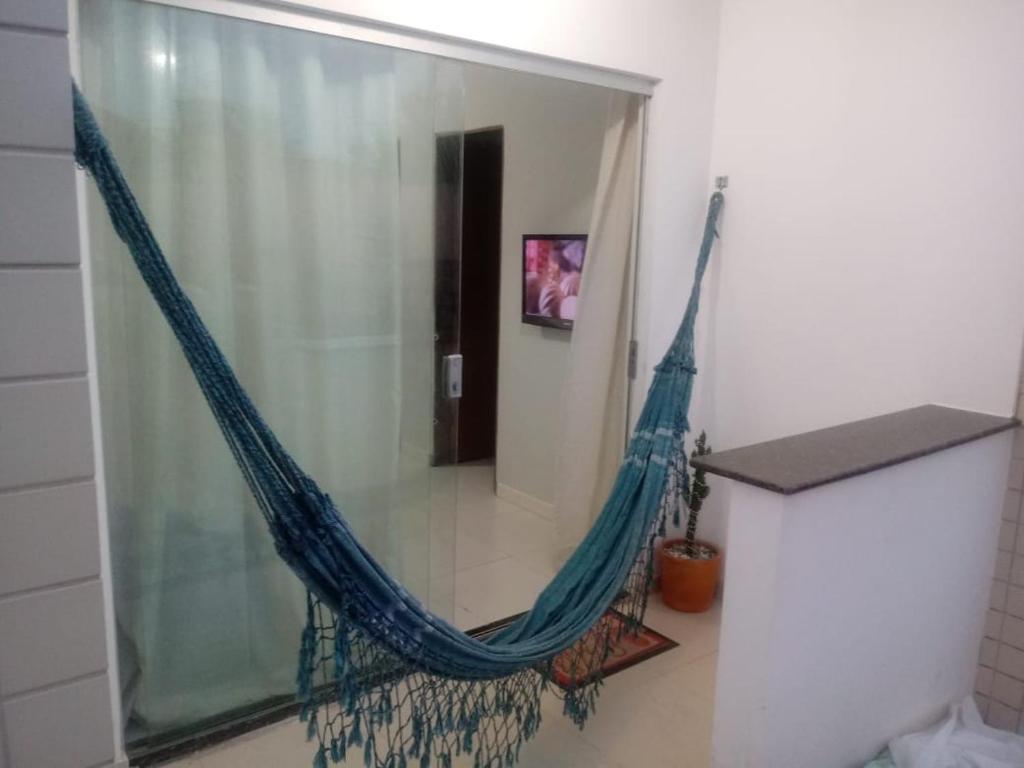 - un hamac suspendu dans une pièce avec un miroir dans l'établissement Apartamento aconchegante 2 quartos com suíte na praia de Guaibim, à Guaibim