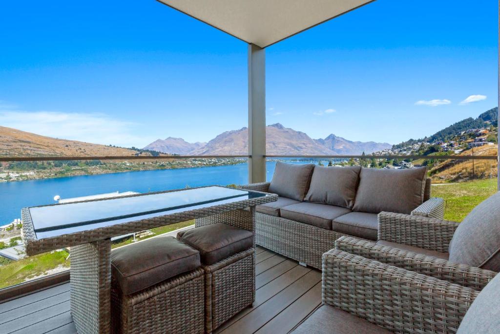 a patio with a table and chairs and a view of the water at Peak View Residence in Queenstown