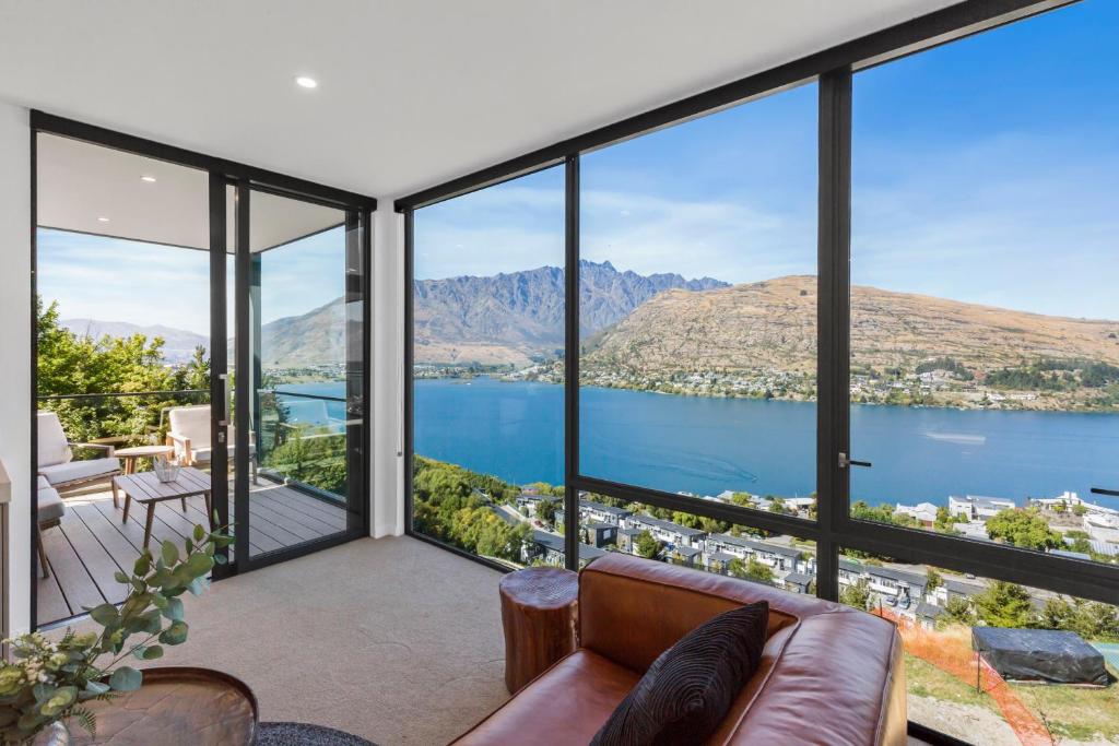 a living room with a view of the water and mountains at Remarkable Views in Queenstown