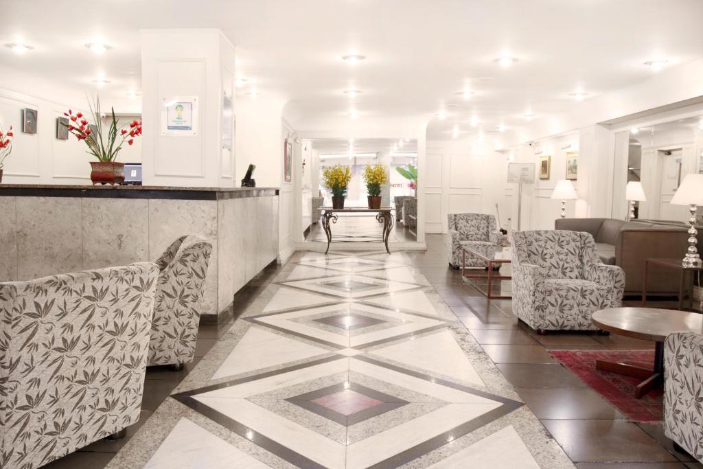 a lobby of a hotel with chairs and a bar at CHA Prime Curitiba in Curitiba