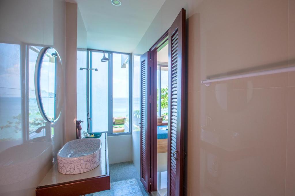 a bathroom with a tub and a sink and a mirror at Norn Talay Surin Beach Phuket in Surin Beach