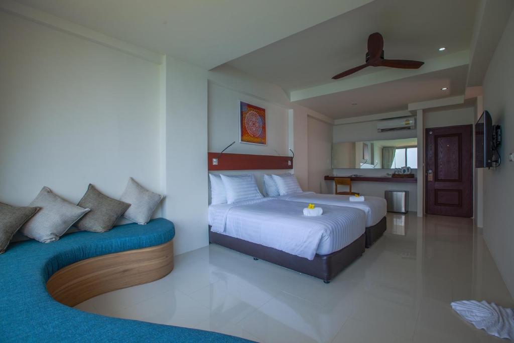 a bedroom with two beds and a kitchen at Norn Talay Surin Beach Phuket in Surin Beach