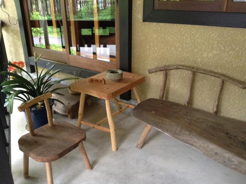 una mesa y un banco, una mesa y una silla en Inn Wataboshi, en Hakuba