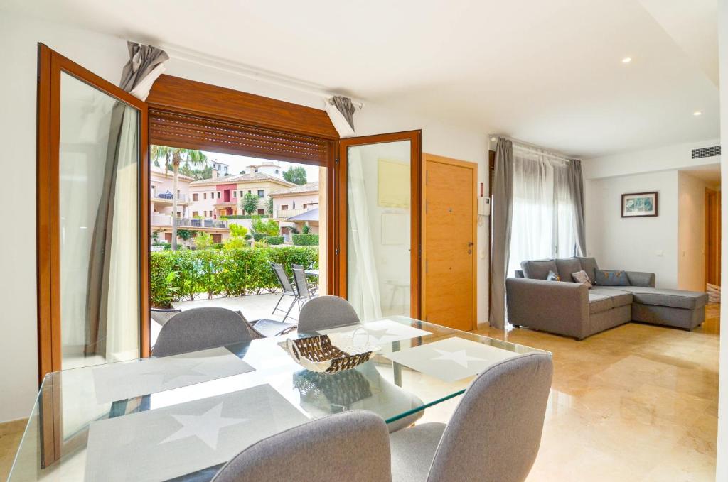 ein Esszimmer mit Glastisch und Stühlen in der Unterkunft Jardines de Montemar in Benissa