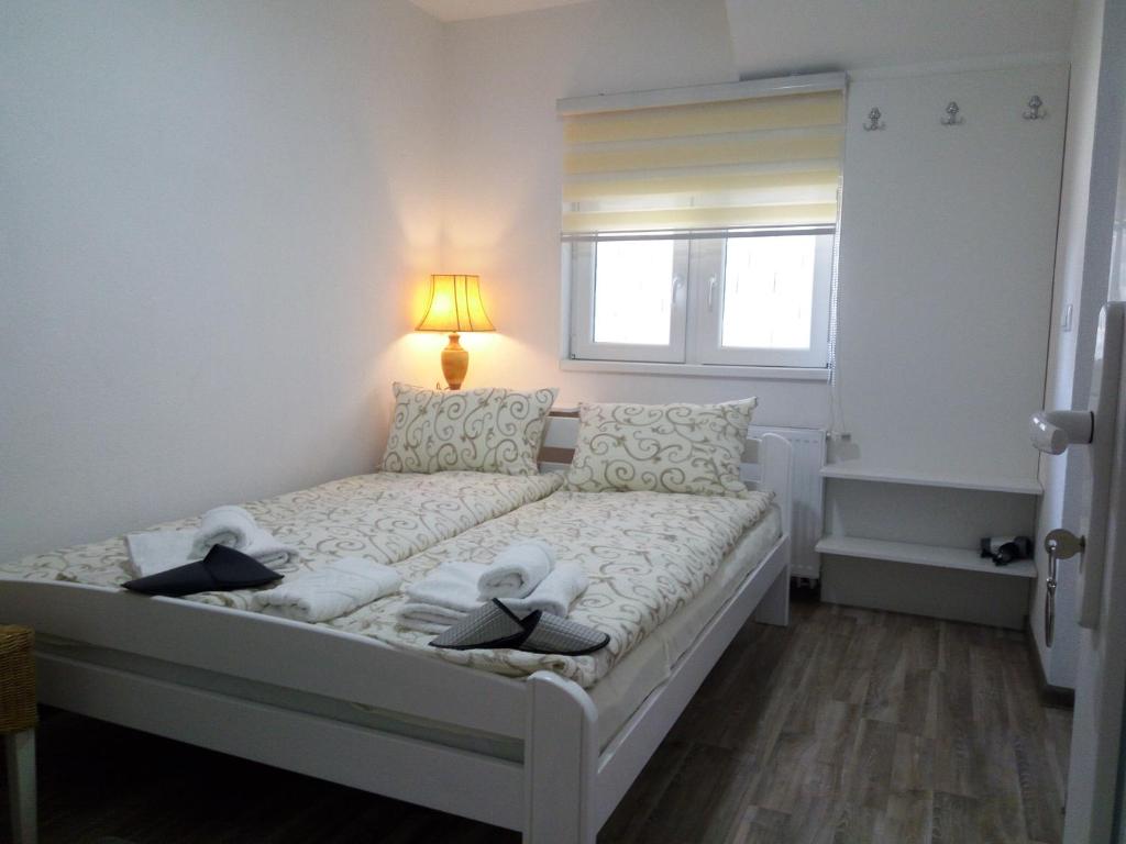 1 dormitorio con 1 cama con toallas en Apartments&Rooms Mido, en Visoko