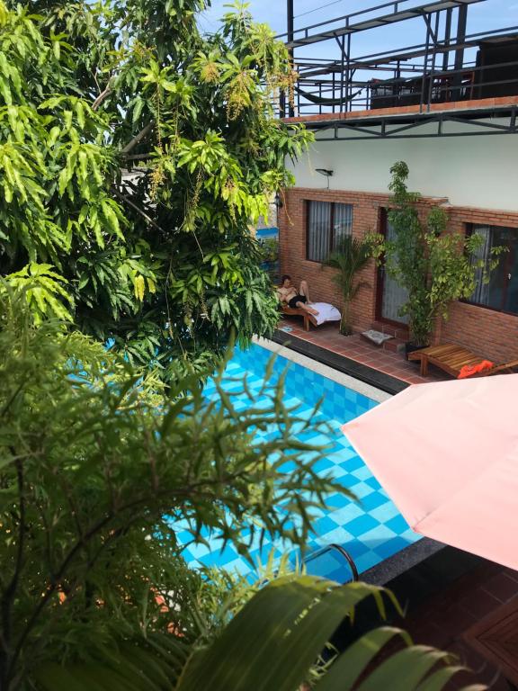 uitzicht op een zwembad met bomen bij Mui Ne Garden Hotel and Kite School in Mũi Né