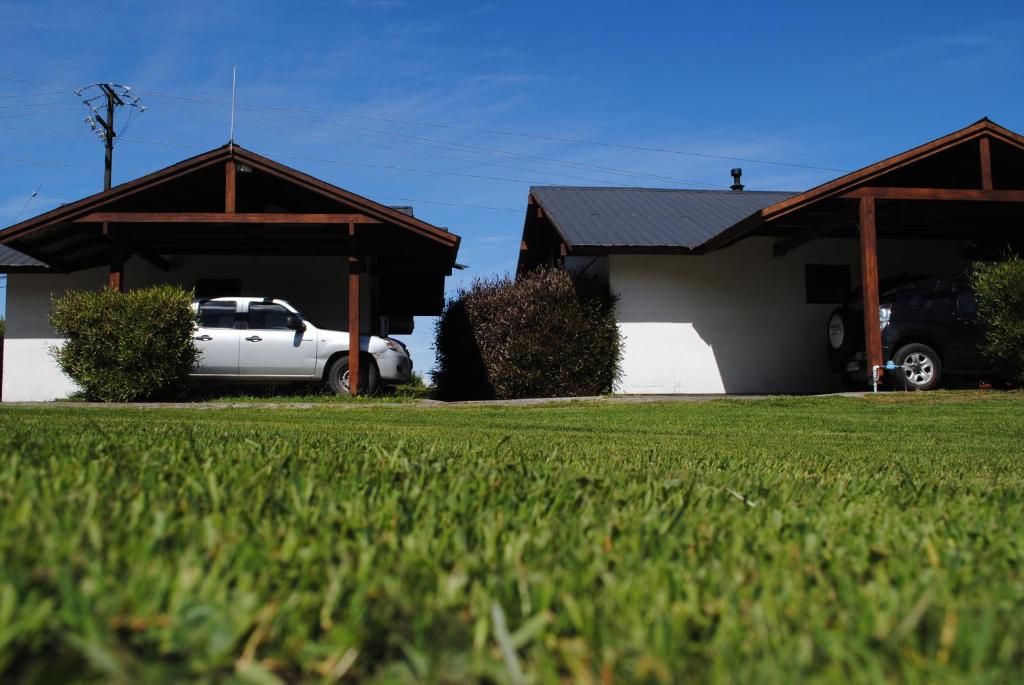 un camión blanco estacionado frente a una casa en Cabañas de Turismo Araucarias del Sur, en Puerto Varas