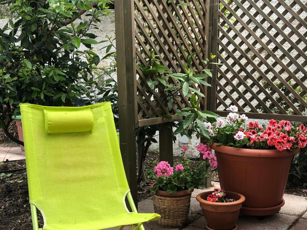 una sedia verde seduta accanto a fiori e piante di La Lantana Nuova a Flumini di Quartu