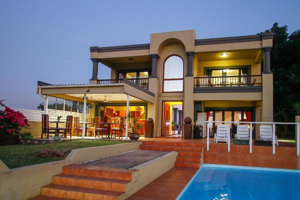 dom z basenem przed nim w obiekcie Virginia Forest Lodge w mieście Durban