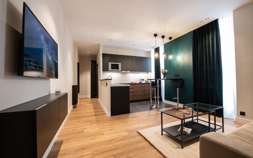 un soggiorno e una cucina con divano e tavolo di Monaco Central 1 bedroom appartement a Beausoleil