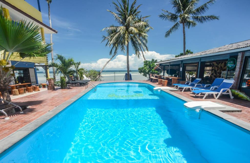 una piscina en un complejo con palmeras y el océano en Carabao Diving Koh Tao, en Ko Tao