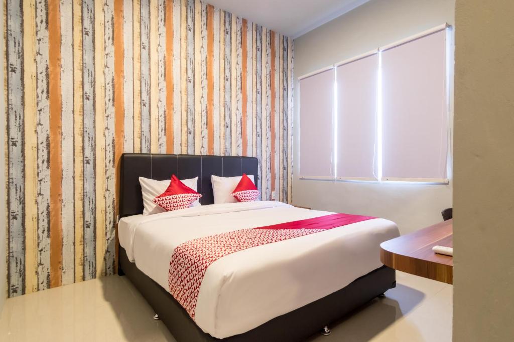 a bedroom with a bed with red pillows at Super OYO 360 Mangaan Residence in Medan